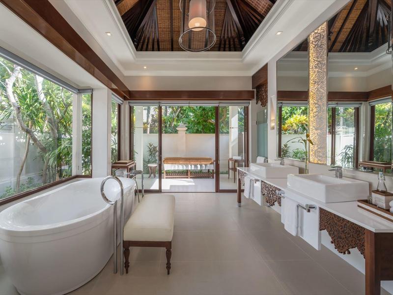 Prostorná koupelna s volně stojící vanou, dvojnásobnými umyvadly a výhledem na terasu.