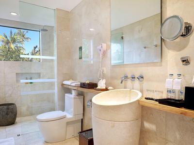 Moderne badkamer met lichte marmer, grote douche en ronde wastafel.