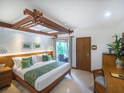 Helles Schlafzimmer mit großem Bett, Holzdecke, Schreibtisch, Pflanzen und Balkonblick.