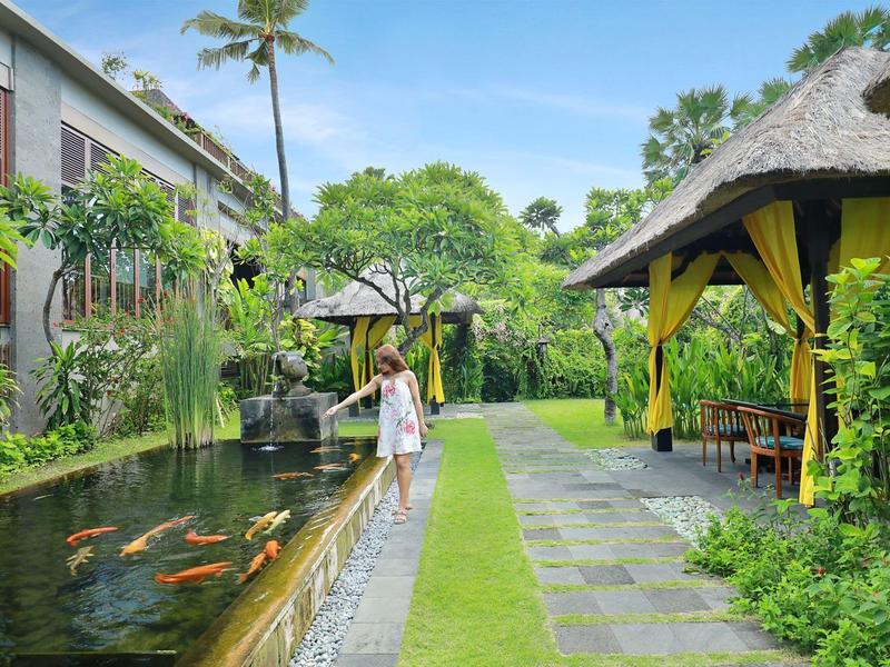 Hotel tuin met vijver en koi-karpers, ontspannen sfeer en tropische planten