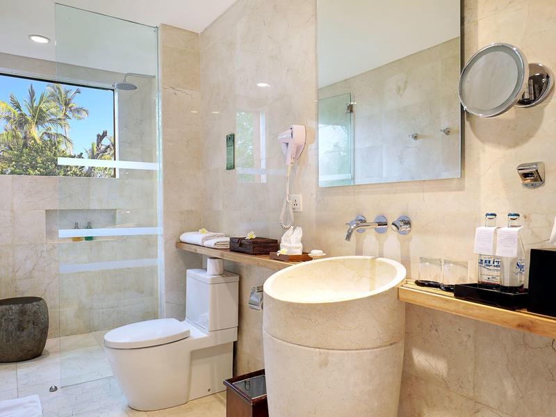 Moderne badkamer met lichte marmer, grote douche en ronde wastafel.