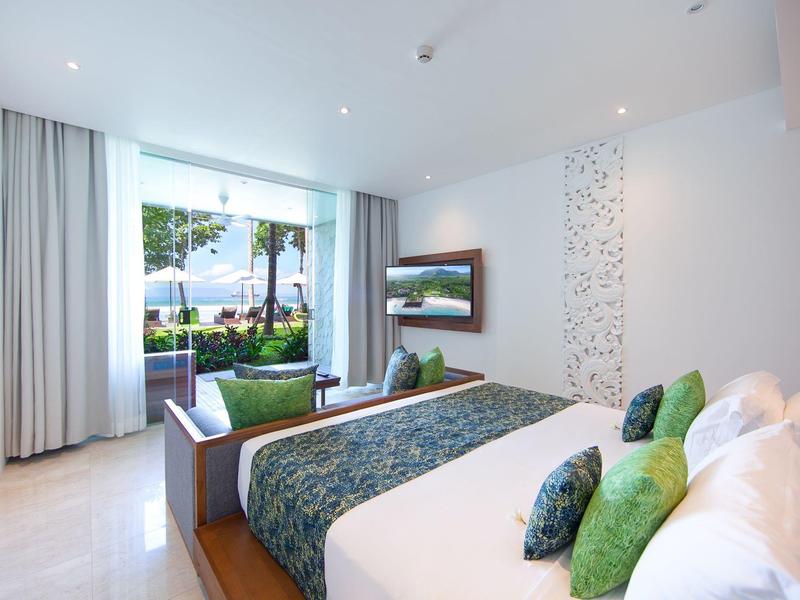 Modernes Schlafzimmer mit großem Fenster, hellen Wänden, grünen Akzenten und Meerblick.