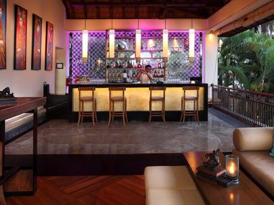 Moderne hotelbar en lounge met balie, zitplaatsen en sfeerverlichting.