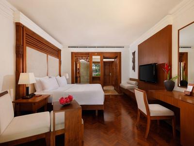 Elegant hotelkamer met tweepersoonsbed, houten meubels en bureau met tv.