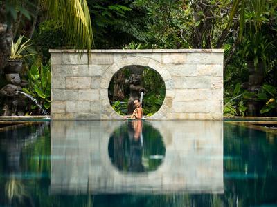 Elegant hotelkamer met groot bed, houten vloer en zithoek met uitzicht op de natuur.
