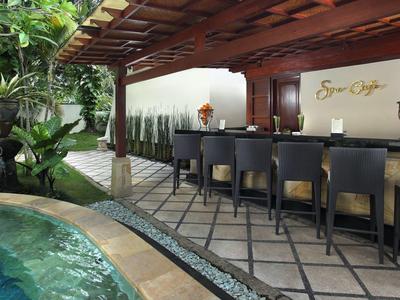 Moderne buitenzwembad met zitplaatsen en bar onder houten overkapping.