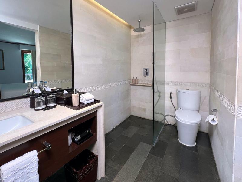 Moderne badkamer met douche, toilet en wastafel in een licht, neutraal ontwerp.