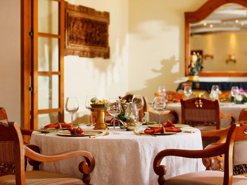 Elegant gedekte eettafel in warme, uitnodigende restaurantomgeving.