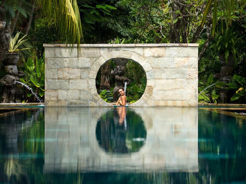 Elegant hotelkamer met groot bed, houten vloer en zithoek met uitzicht op de natuur.
