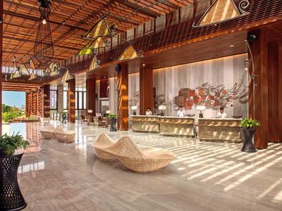 Helle Hotellobby mit Holzakzenten, modernen Sitzbereichen und großer Fensterfront.