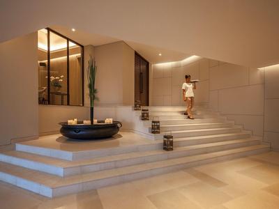 Moderner Eingangsbereich mit Treppen, Pflanzen und warmen Beleuchtungskonzept.