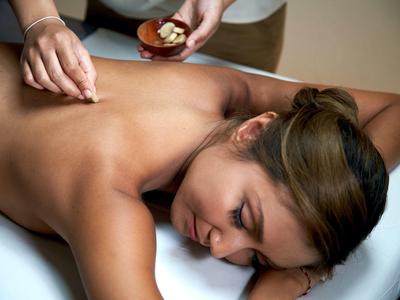 Frau erhält entspannende Rückenmassage in einem Spa- oder Wellnesshotel.