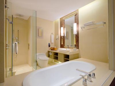 Helles Badezimmer mit Badewanne, Dusche, Toilette und Waschbecken mit Spiegel.