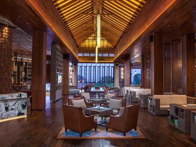 Luxuriöse Hotellobby mit Holzbalkendecke, Ledersesseln und moderner Einrichtung.