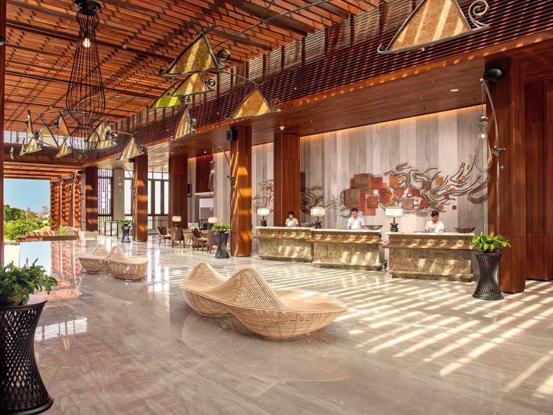 Helle Hotellobby mit Holzakzenten, modernen Sitzbereichen und großer Fensterfront.