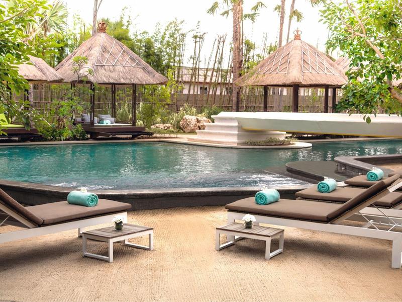 Entspannende Poollandschaft mit Liegestühlen und Pavillons in tropischer Umgebung.
