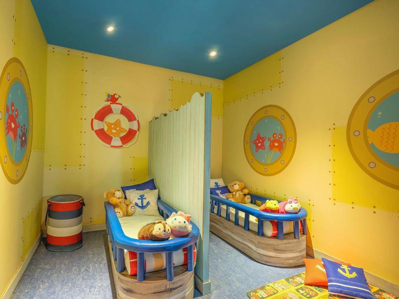 Buntes Kinderzimmer mit Spielbetten und Meeresdekoration.
