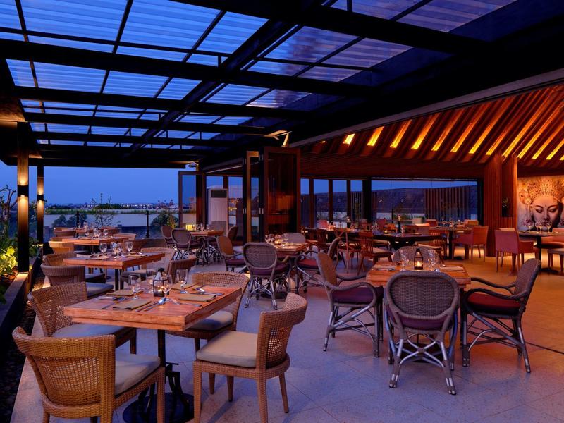 Elegancka restauracja z szklanym dachem i widokiem na miasto o zmierzchu