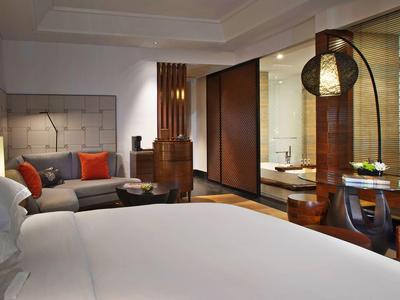 Camera d'hotel moderna con un grande letto, area salotto e scrivania.