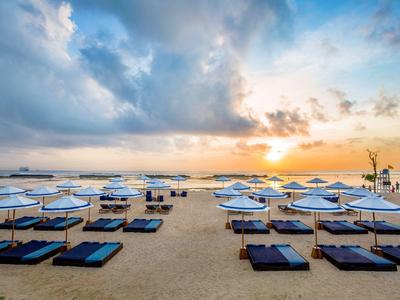 Spiaggia con più ombrelloni e lettini al tramonto