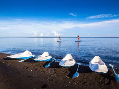 Chef portant un chapeau blanc grillant avec des flammes et de la fumée en plein air la nuit près d'un restaurant