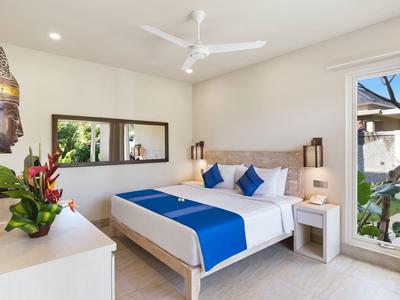 Bright bedroom with double bed, blue accents, and garden view.