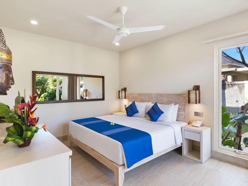 Bright bedroom with double bed, blue accents, and garden view.