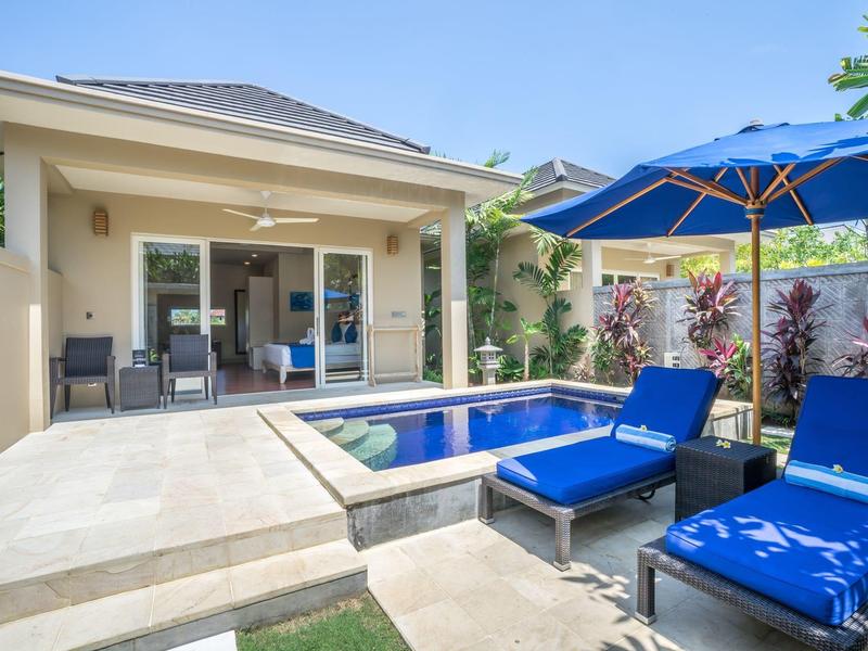 Modern bungalow with private pool, terrace, and blue loungers under a blue umbrella.