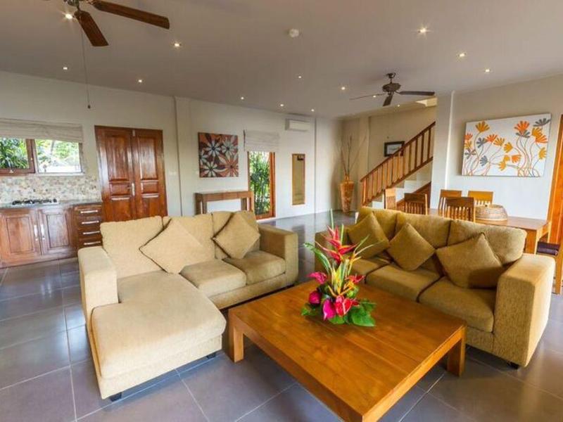 Spacious living room with comfortable sofas, wooden table, and modern decor in a vacation home.