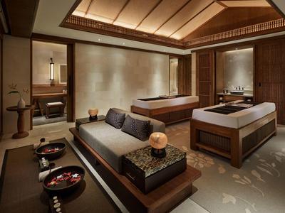 Salle de spa moderne avec tables de massage et ambiance cosy.