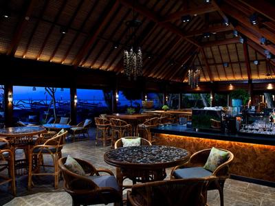 Bar d'hôtel confortable avec intérieur en bois rustique et vue sur le ciel du soir.