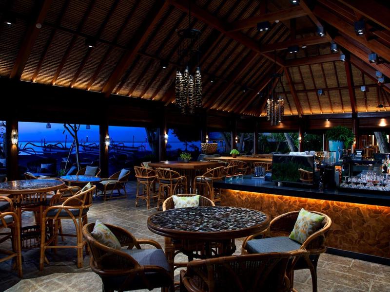 Bar d'hôtel confortable avec intérieur en bois rustique et vue sur le ciel du soir.