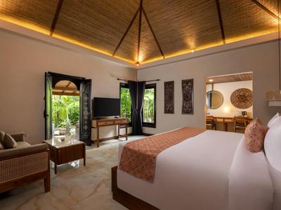 Przytulny pokój hotelowy z drewnianym sufitem, łóżkiem, sofą i wyjściem na zewnątrz.