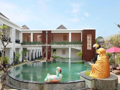 Modern pool with a Buddha statue and a flamingo in a hotel complex.