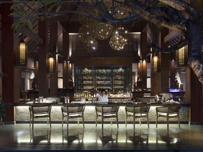 Elegante Hotelbar mit beleuchtetem Tresen, hohen Stühlen und stilvoller Beleuchtung bei Nacht