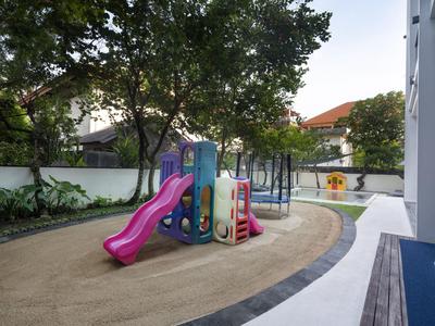 Zona de juegos para niños con tobogán y trampolín en el patio interior de un hotel.