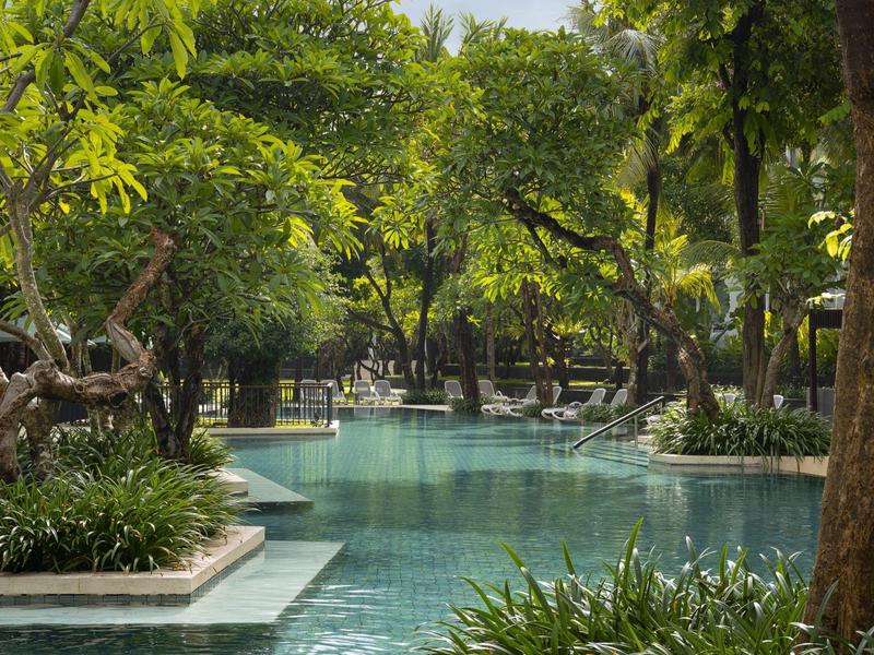 Una piscina tranquila rodeada de vegetación exuberante en un hotel tropical.
