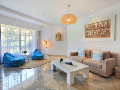 Soggiorno luminoso con divani, poltrone colorate e tavolino in un'atmosfera accogliente.