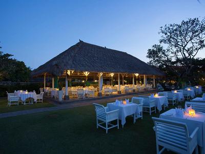 Ristorante all'aperto elegante con tavoli bianchi e atmosfera al crepuscolo.