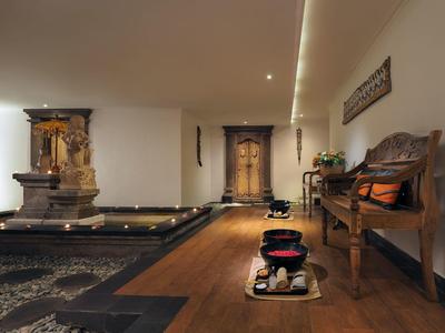 Ingresso hotel elegante con fontana, panche in legno e decorazioni accoglienti.