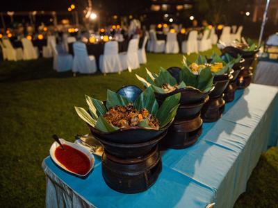 Buffet all'aperto con vari piatti disposti su un tavolo per una cena serale.