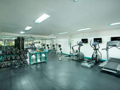 Palestra moderna con tapis roulant, cross trainer e manubri in un hotel.