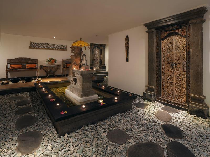 Interno lussuoso con fontana centrale, decorazioni alle pareti e porta ornata.