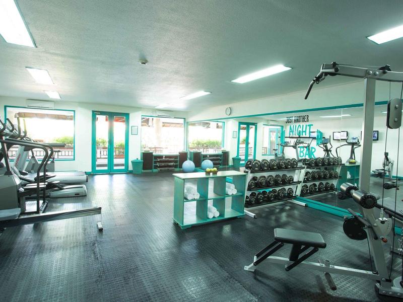 Palestra luminosa con attrezzature moderne e pesi liberi.