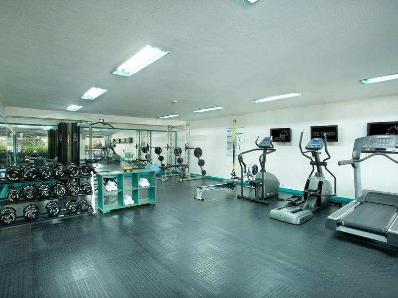 Palestra moderna con tapis roulant, ellittiche e pesi liberi.