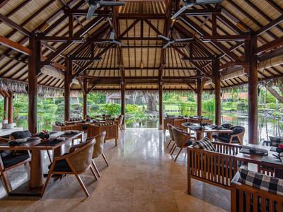 Restaurant ouvert avec toit en bois et décoration moderne donnant sur le jardin.