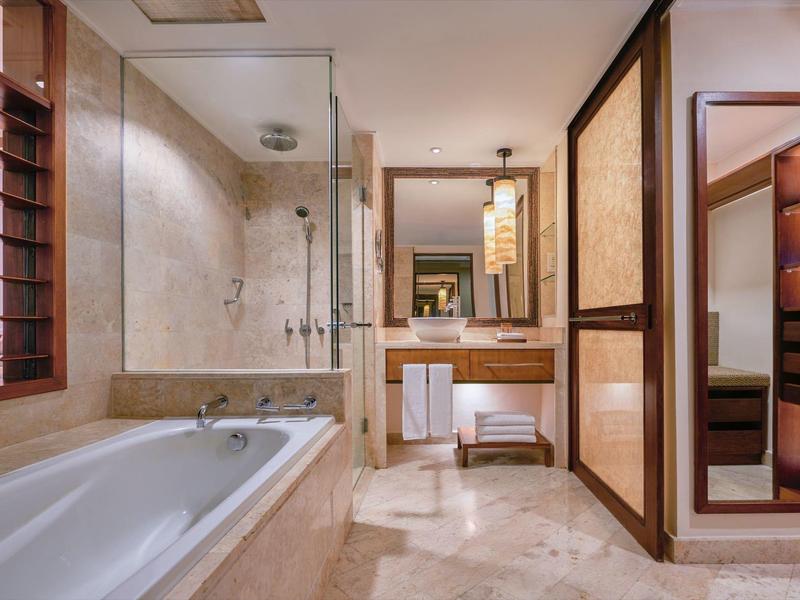 Salle de bain lumineuse avec baignoire, douche et grand miroir de style moderne