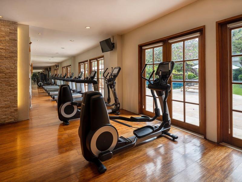 Salle de sport avec équipements modernes et grandes fenêtres donnant sur l'extérieur.