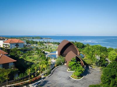 Nadmorski kurort z willami, bujną zielenią i widokiem na ocean pod czystym niebieskim niebem.