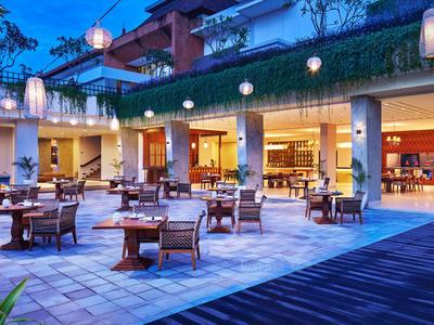 Abendterrasse eines Hotels mit Sitzgruppen und Beleuchtung unter einem blauen Himmel.